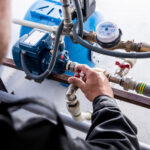 Technician checking water system nodes. Modern Industrial background.